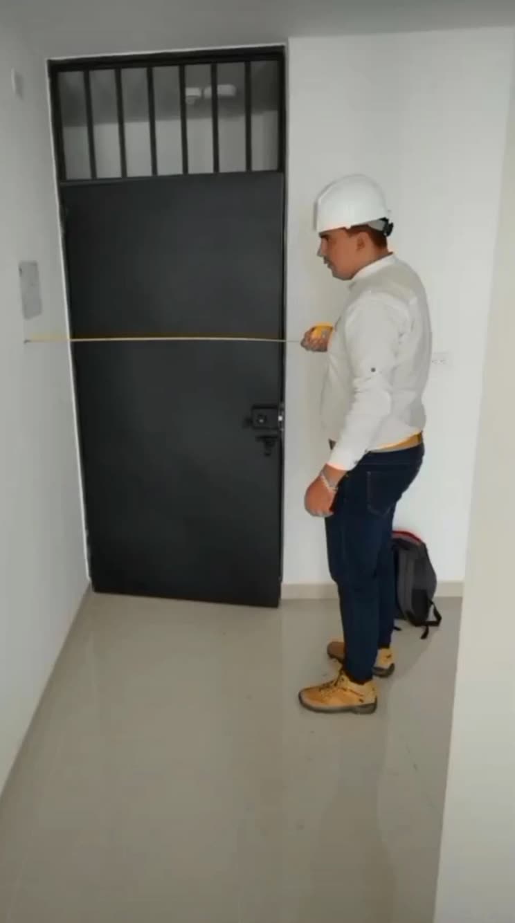Ingeniero de Dielec midiendo distancias de seguridad con cinta métrica en una inspección RETIE
