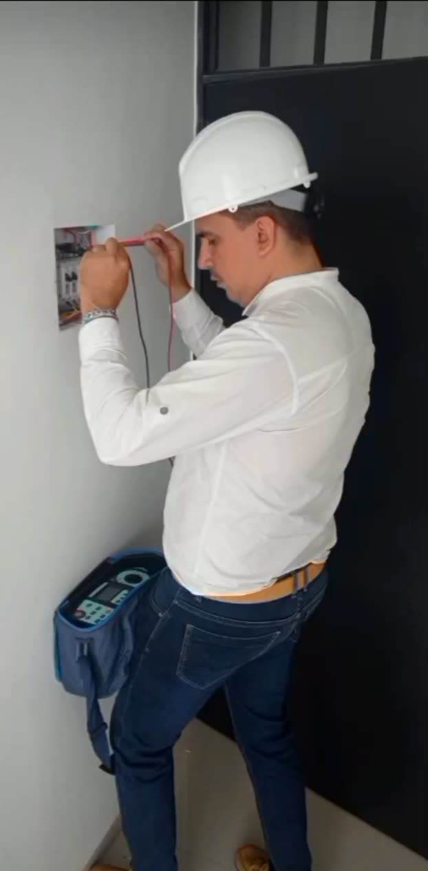 Ingeniero de Dielec midiendo tensión y continuidad en un tablero eléctrico con puntas de prueba